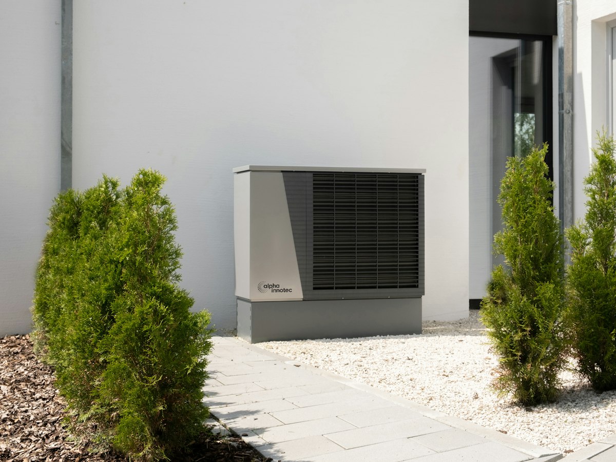 Unité extérieure de pompe à chaleur air-air fixée sur la façade d'une maison